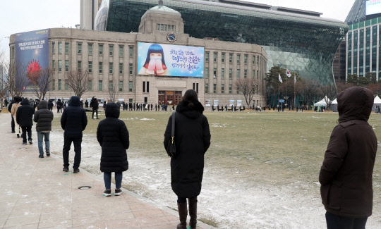 18일 코로나19 중구 임시선별검사소가 마련된 서울 시청 앞 광장에서 시민들이 검사를 받기 위해 줄을 서 대기하고 있다. 연합뉴스
